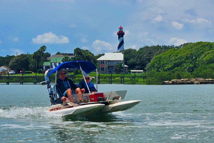 a man riding on the back of a boat in the water