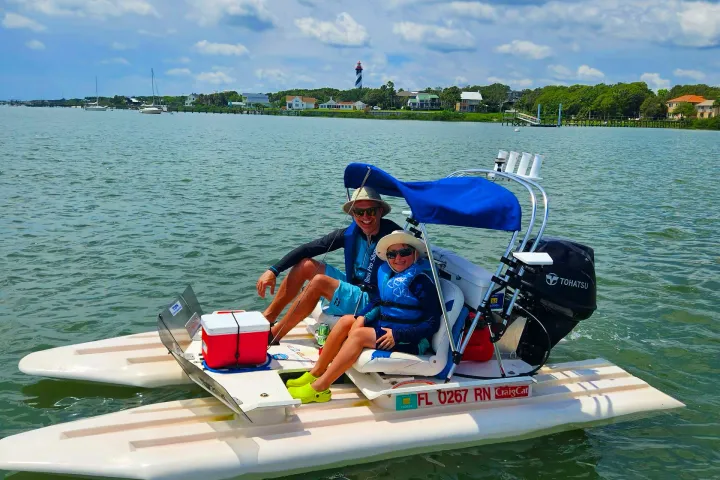 a man riding on the back of a boat in a body of water