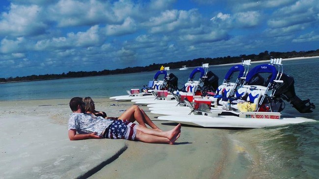 Couple on beach next to catamarans