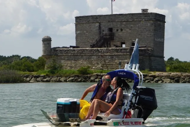 a man riding on the back of a boat in a body of water