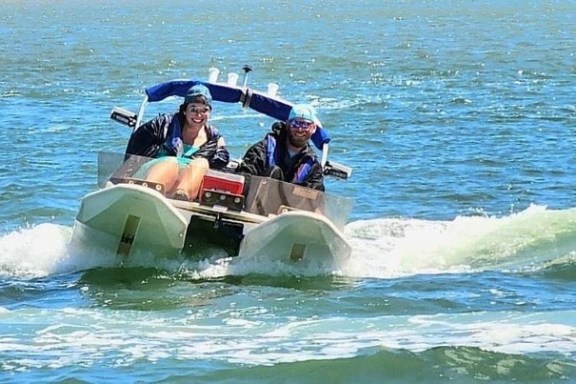a man riding on the back of a boat in the water