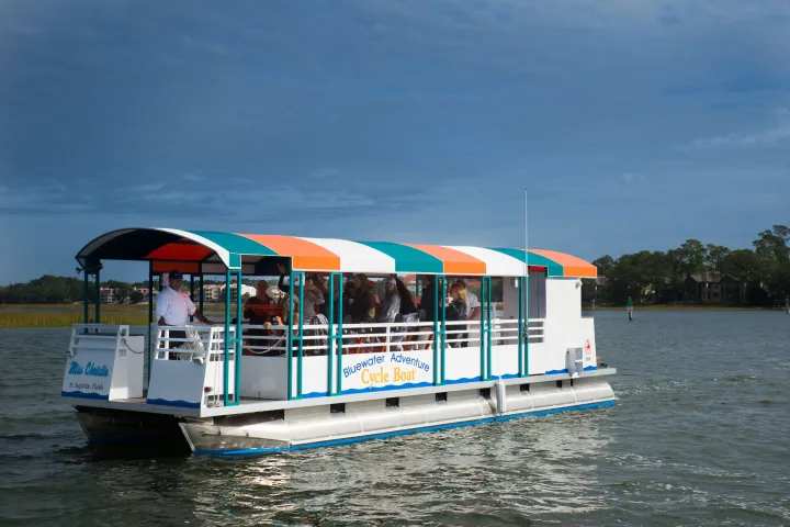 a blue and white boat sitting next to a body of water